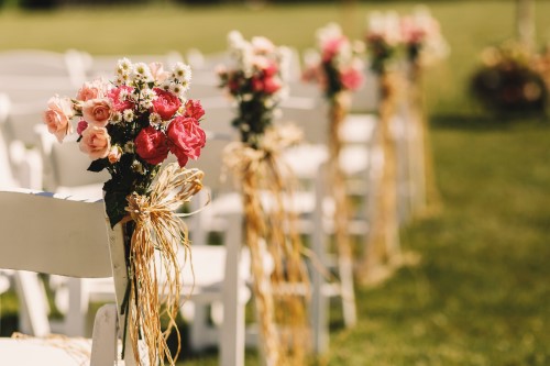 Zjawiskowe i proste dekoracje krzeseł na ślubie w plenerze